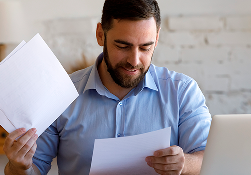 Hombre leyendo contratos y documentos